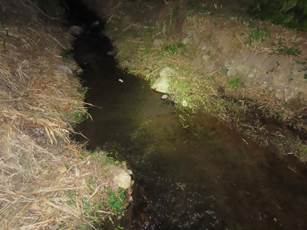 A stream of water in a dark area

Description automatically generated